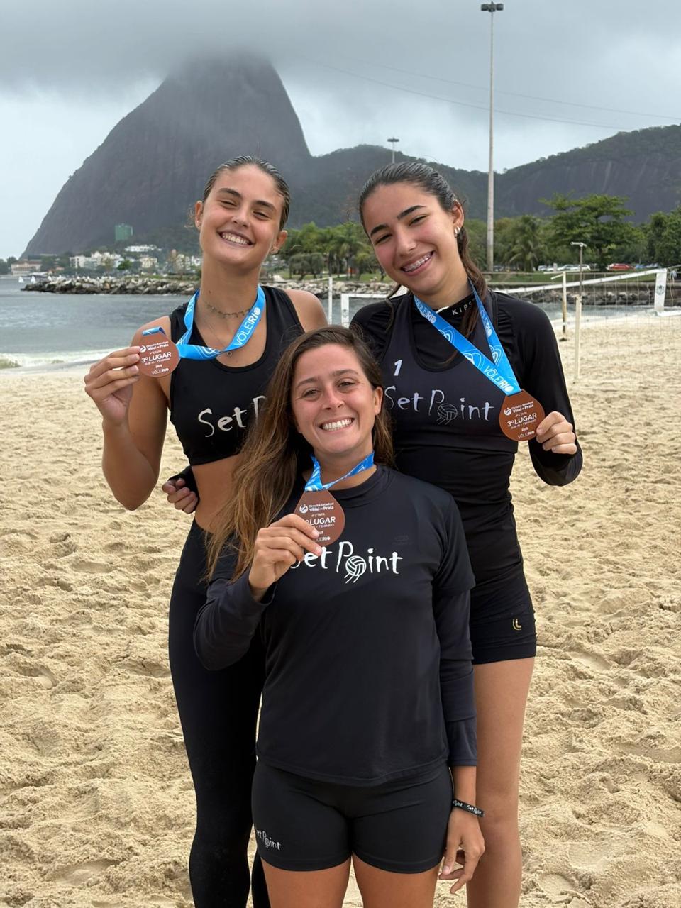 Atletas Set Point com medalhas e o Pão de Açúcar ao fundo