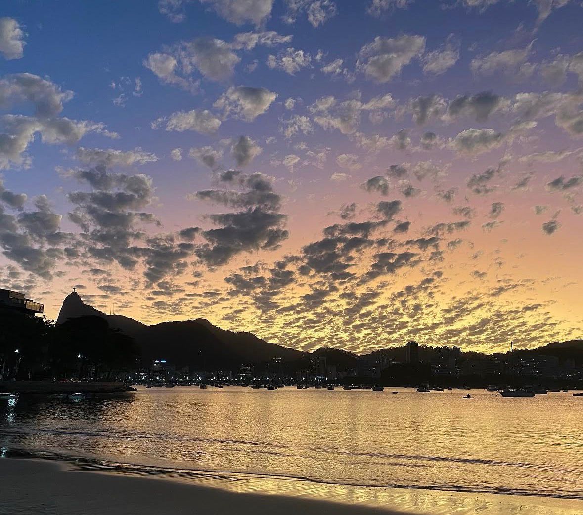 Pôr do sol na Praia da Urca com montanhas ao fundo